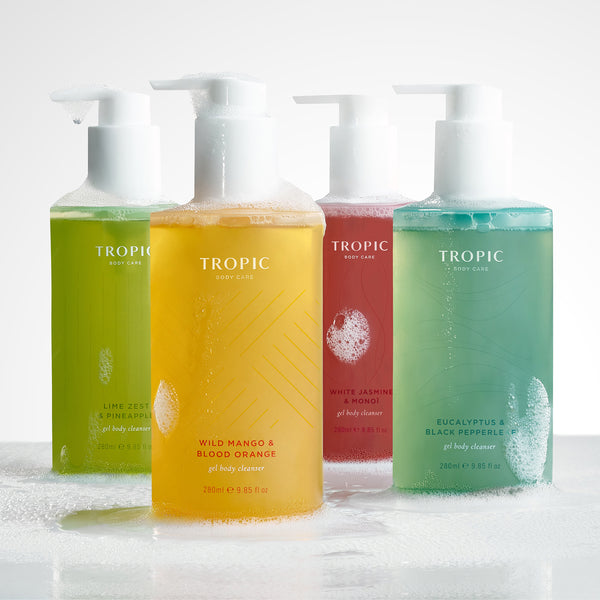 Group of four gel body cleansers in green, yellow, pink and blue.