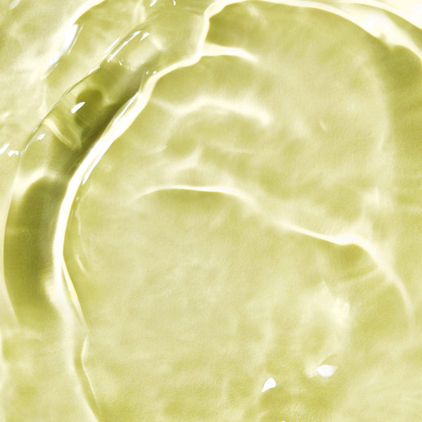 Close-up of golden-yellow oil texture with soft ripples and reflections, showcasing a glossy and radiant surface suggestive of nourishing hair oil.