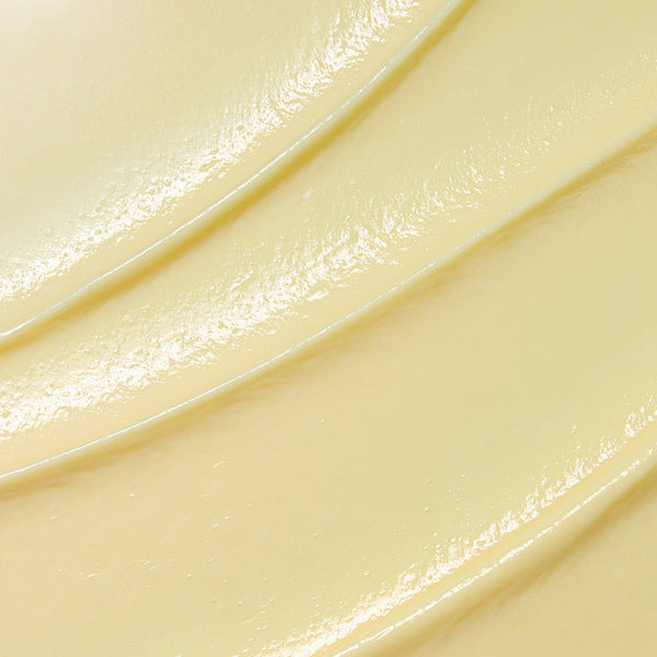 Close-up texture of creamy pale yellow buttercream with smooth, glossy ridges showing a rich, hydrating consistency.