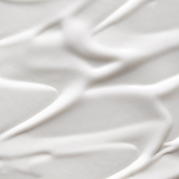 Close-up texture of Tropic Signature Hand Lotion, showing smooth, creamy white swirls with a rich, hydrating appearance.