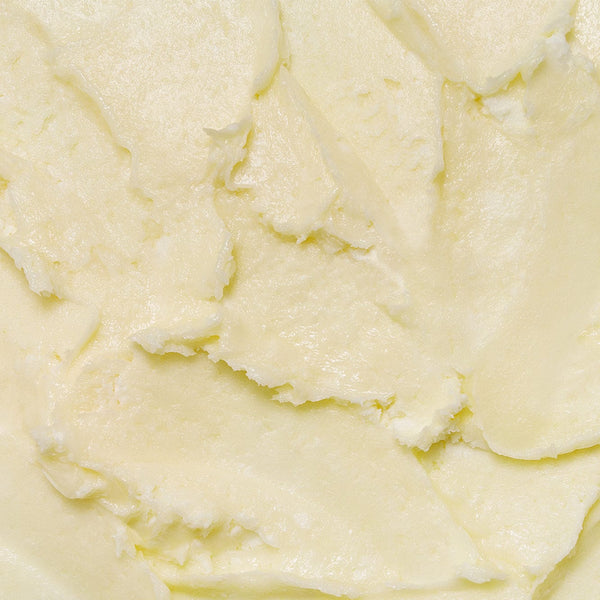 Close-up texture of Tropic Whipped Body Velvet, showing its rich, creamy, buttery consistency in a pale yellow shade that highlights its deeply nourishing formula.