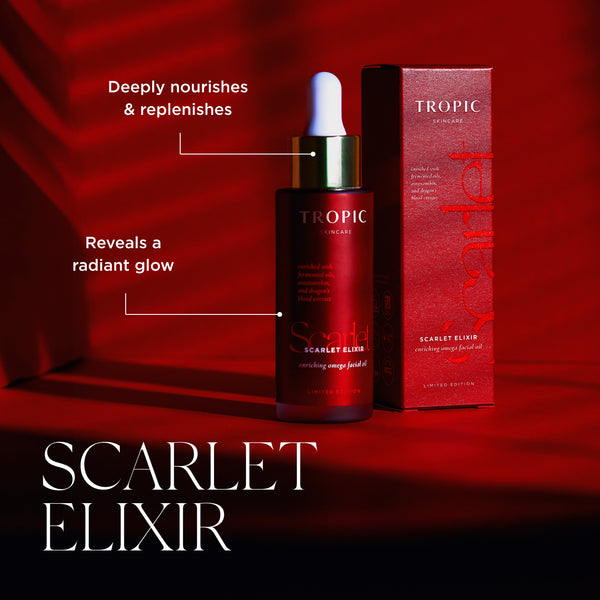 Tropic Scarlet Elixir serum bottle with dropper next to its red packaging box, set against a dramatic red background with text overlays describing the product benefits. 'Reveals a radiant glow' & 'Deeply nourishes & replenishes'