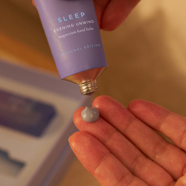 Tropic Sleep Evening Unwind magnesium hand balm being squeezed onto a hand.