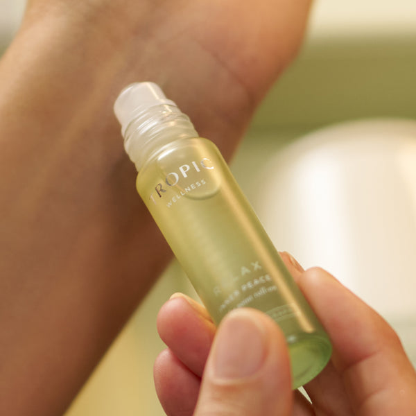 Hand holding Tropic Wellness Relax Inner Peace aromatherapy roller.