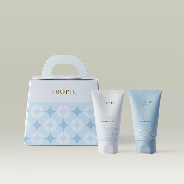 Tropic Body Care Coconut & Tonka Macaron gift set in pale blue, including an exfoliating gel body cleanser and nourishing body cream, with a matching handle gift box.