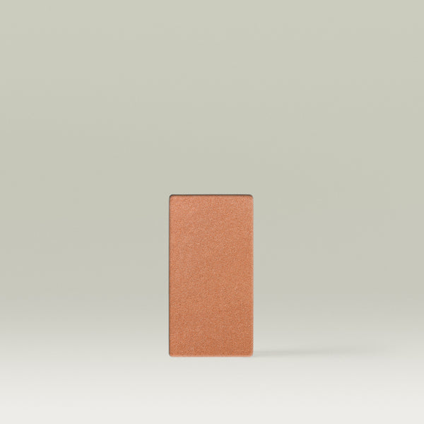 A Tropic Jet Set bronzer refill pan in the shade Havana Heat, shown as a warm deep-bronze rectangular pressed powder pan against a soft neutral background.