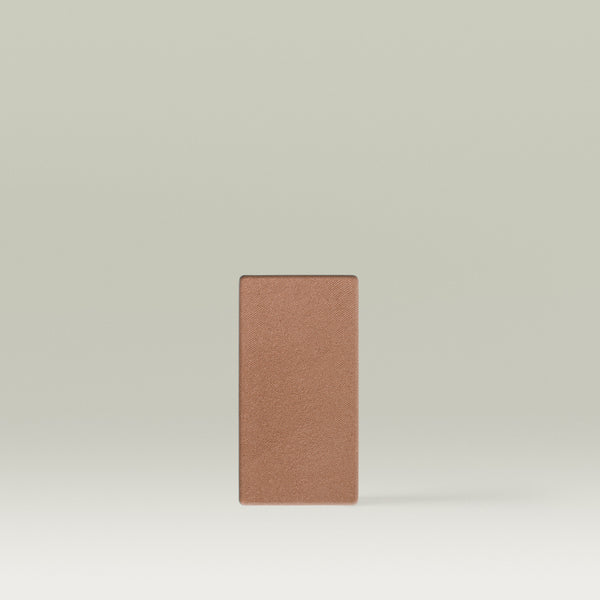 A Tropic Jet Set bronzer refill pan in the shade Tahiti Tan, shown as a medium tan rectangular pressed powder pan against a soft neutral background.