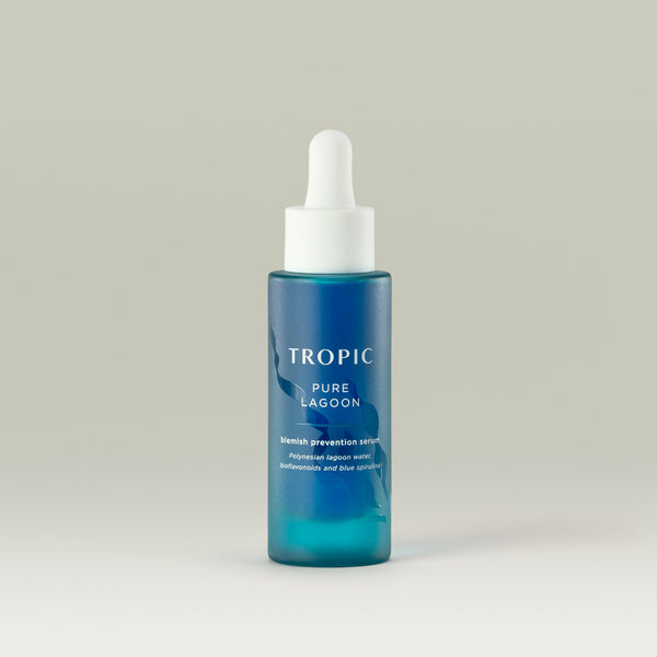 Tropic Pure Lagoon Blemish Prevention Serum in a sleek turquoise-blue glass bottle with a white dropper cap, formulated with Polynesian lagoon water, bioflavonoids, and blue spirulina to clarify and balance the skin.