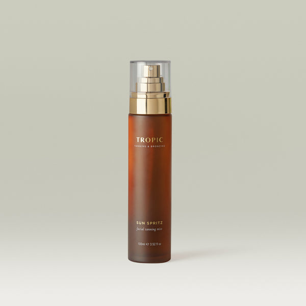 Sun Spritz Facial Tanning Mist by Tropic in an amber glass bottle with a fine mist spray, designed to deliver a natural-looking facial glow with a lightweight, buildable finish.
