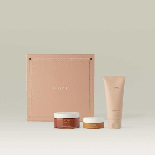 Tropic Body Care gift set featuring Ritual Release warming magnesium polish, Deep Plunge therapeutic magnesium balm, and Mineral Milk body moisturiser, presented in front of a blush pink embossed square gift box.